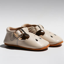 Load image into Gallery viewer, Brooklyn T-bar moccasins for baby girls, featuring soft leather with delicate teardrop cut-out details, adjustable buckle strap, and cushioned ankles for comfort. Available in soft suede soles for younger sizes (0-12 months) and flexible rubber soles for older sizes (12-24 months), these stylish and lightweight shoes are perfect for special occasions and everyday wear.